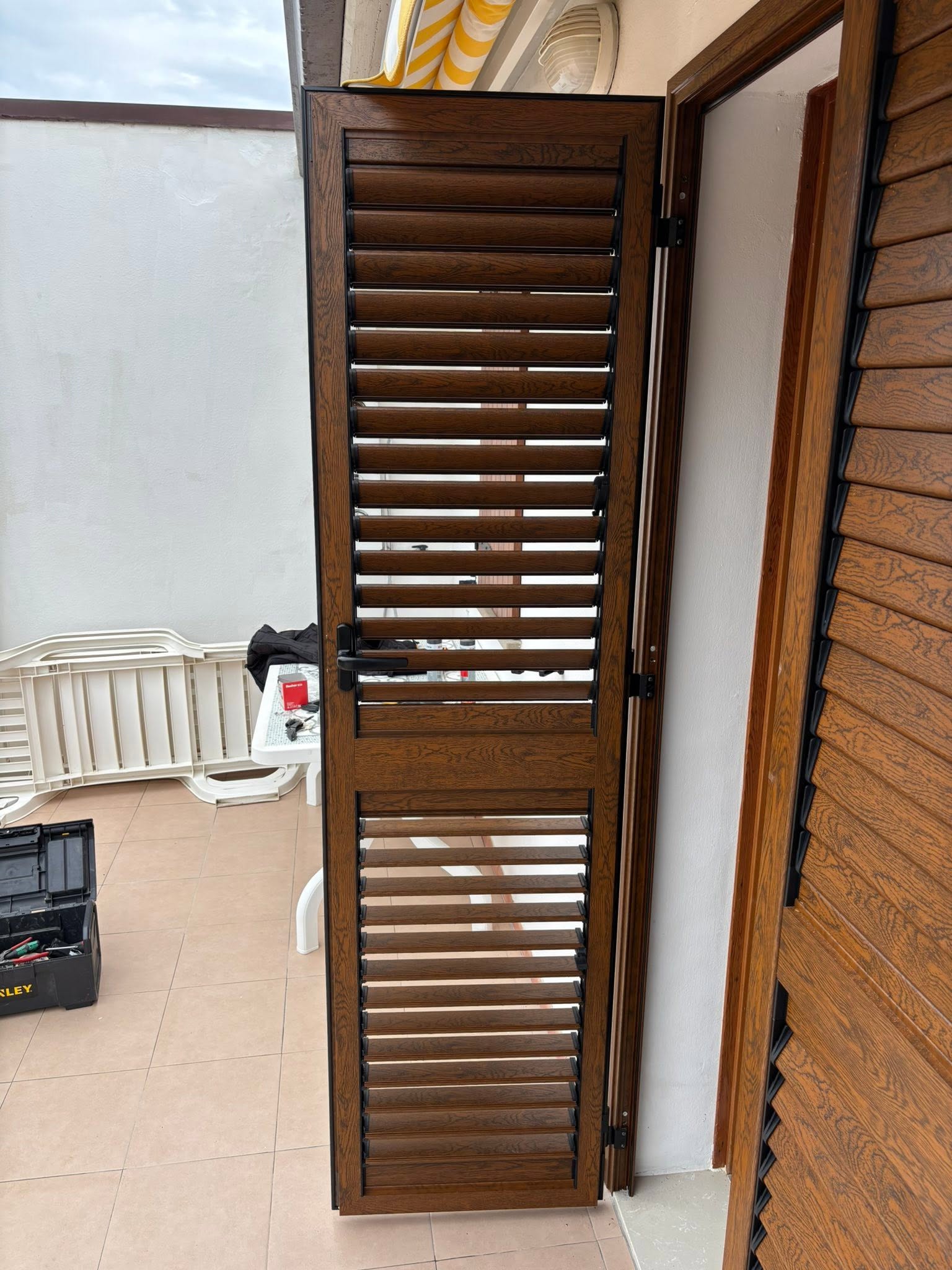 Persiana in finitura legno aperta durante l'installazione